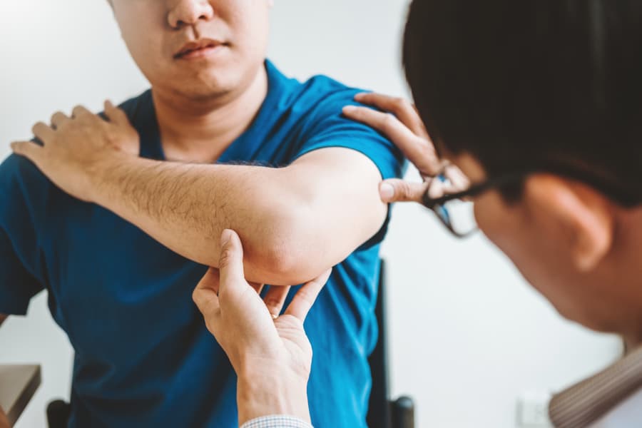 Doctor Examines Patient’s Elbow